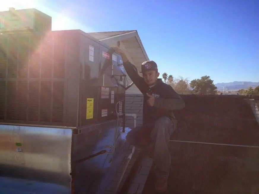 HVAC technician performing Air Duct Repair on a rooftop unit in North Manchester